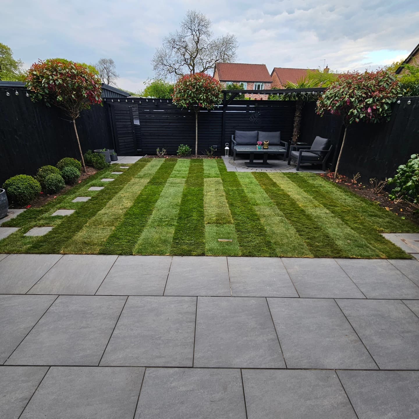 Freshly striped lawn and patio area in a compact domestic garden